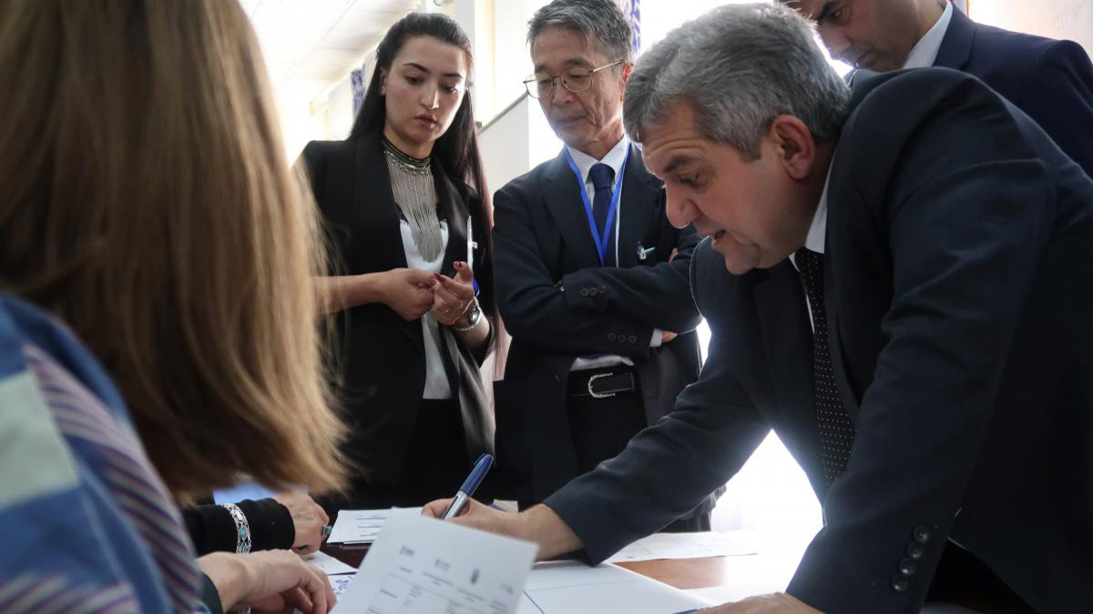 A group of people standing around a table looking at documents