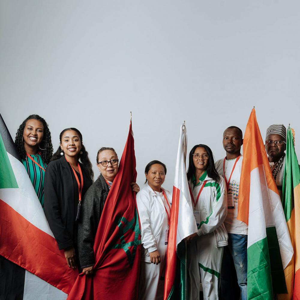 A group of seven people holding flags