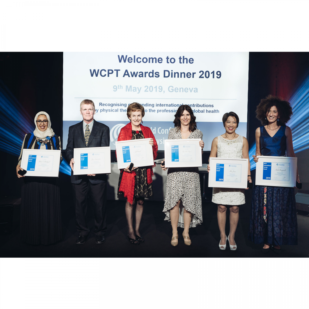 6 of the award-winners stand on stage holding their awards