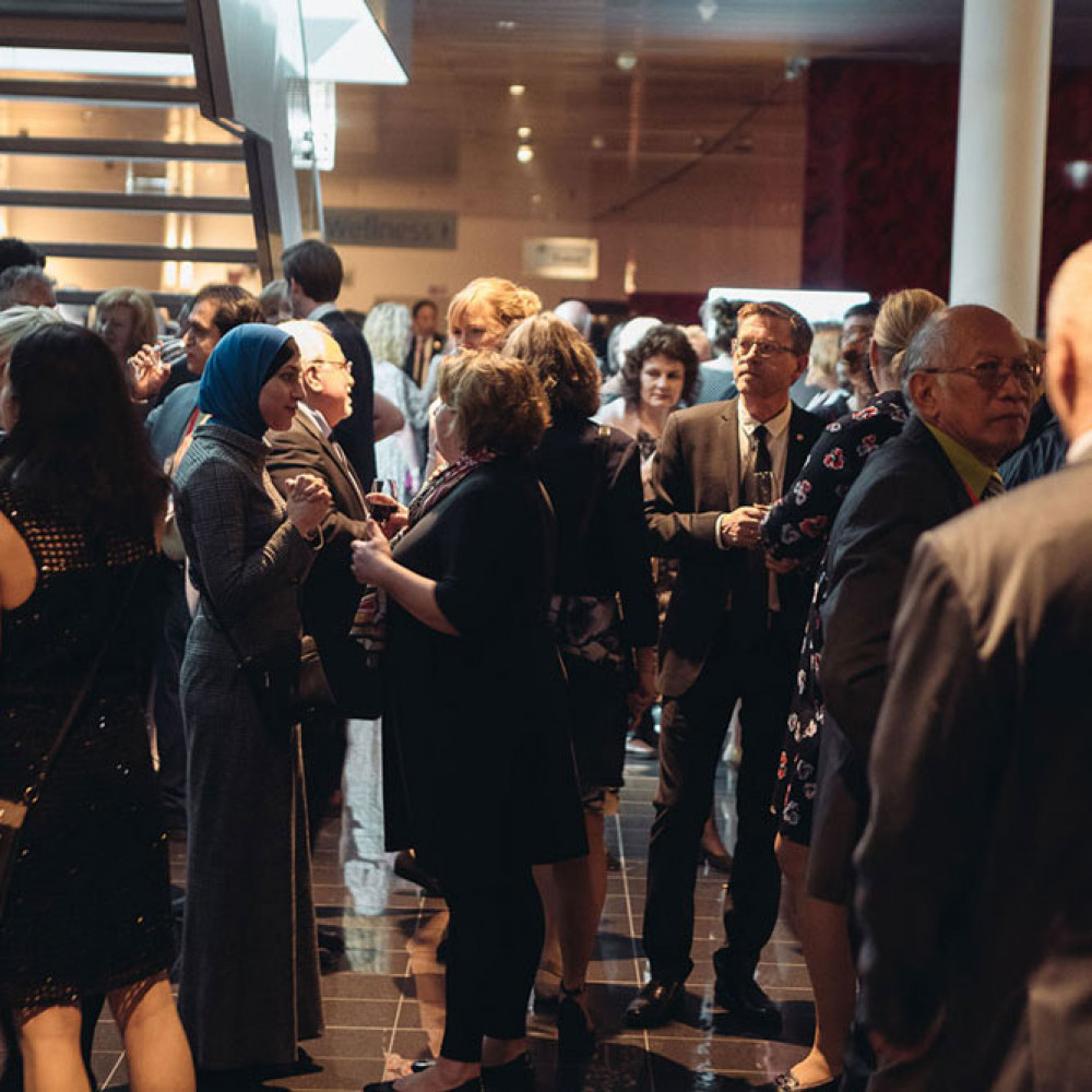 People gather around talking at the awards dinner