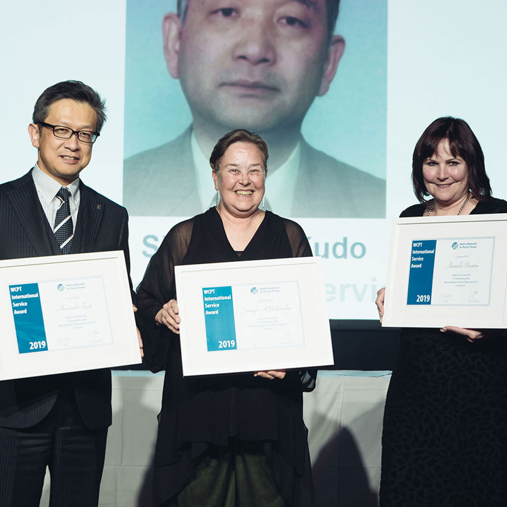 Three award winners holding their framed awards