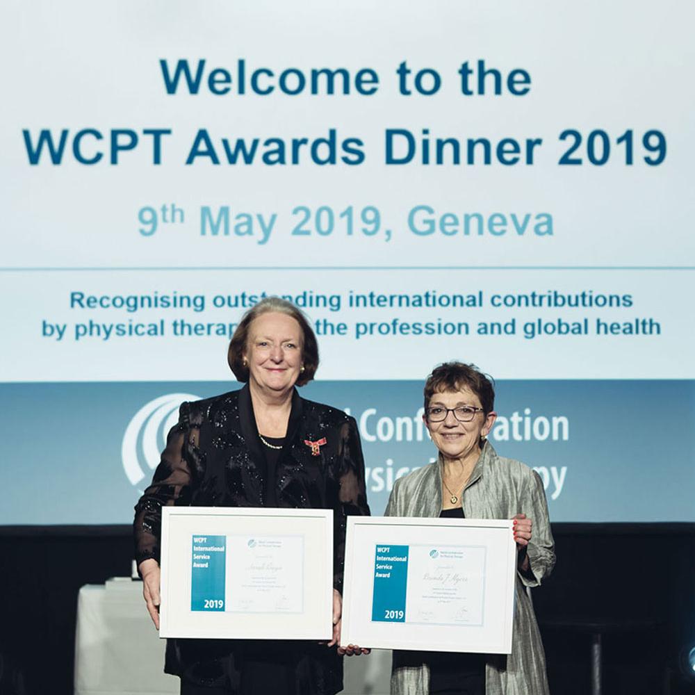 Two women holding framed awards