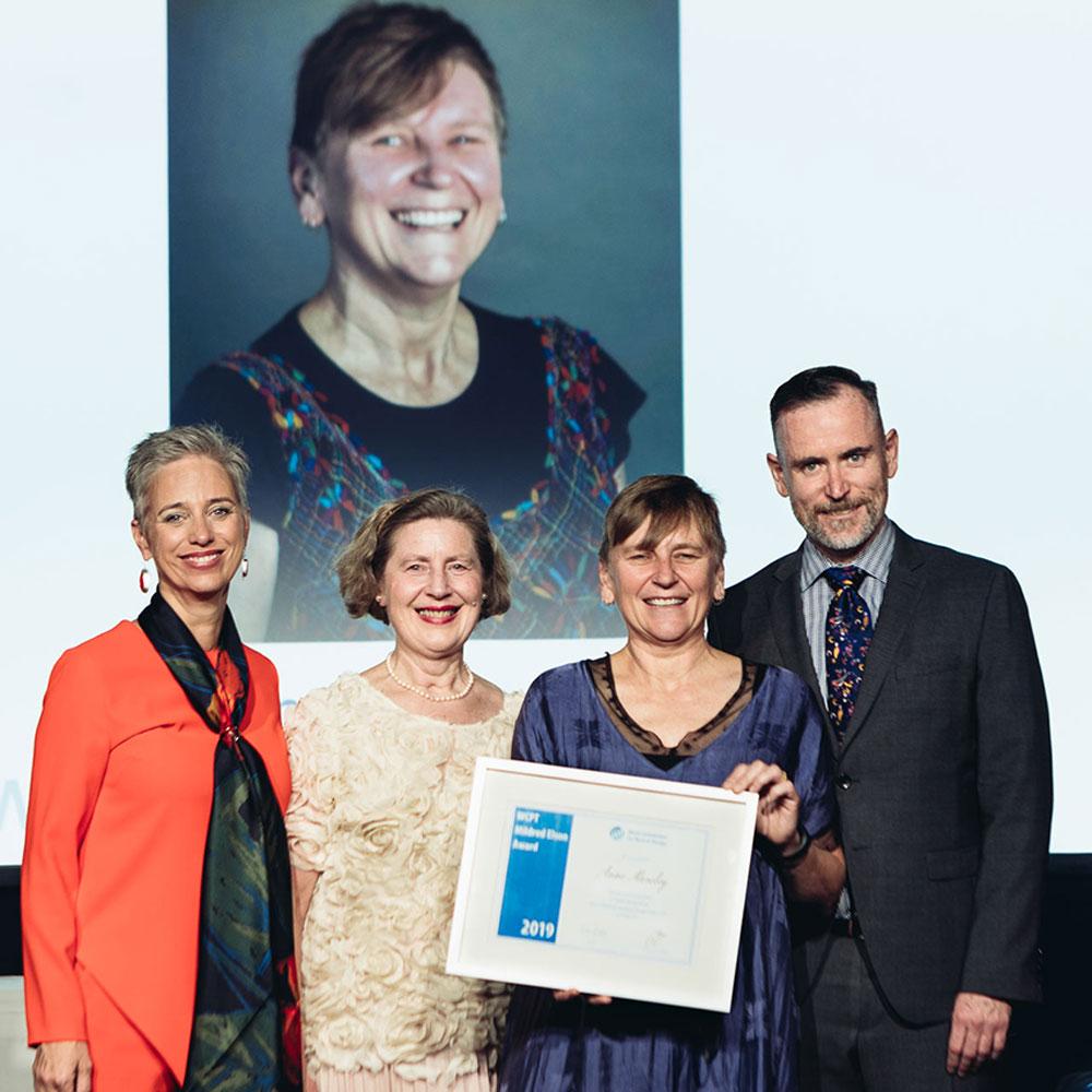 Four people standing together on stage
