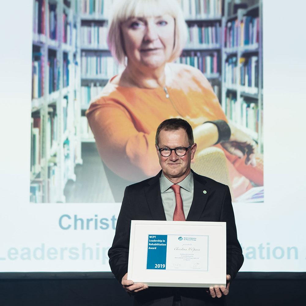 A man holding a framed award