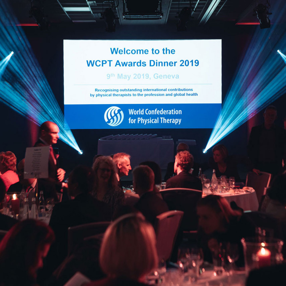 2019年WCPTアワードディナーでテーブルの周りに座っている人々