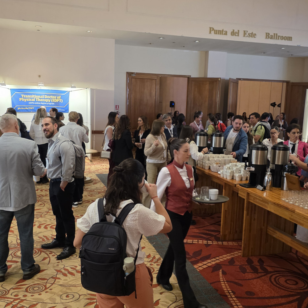 A full and bustling exhibition hall with delegates looking at materials and in discussions