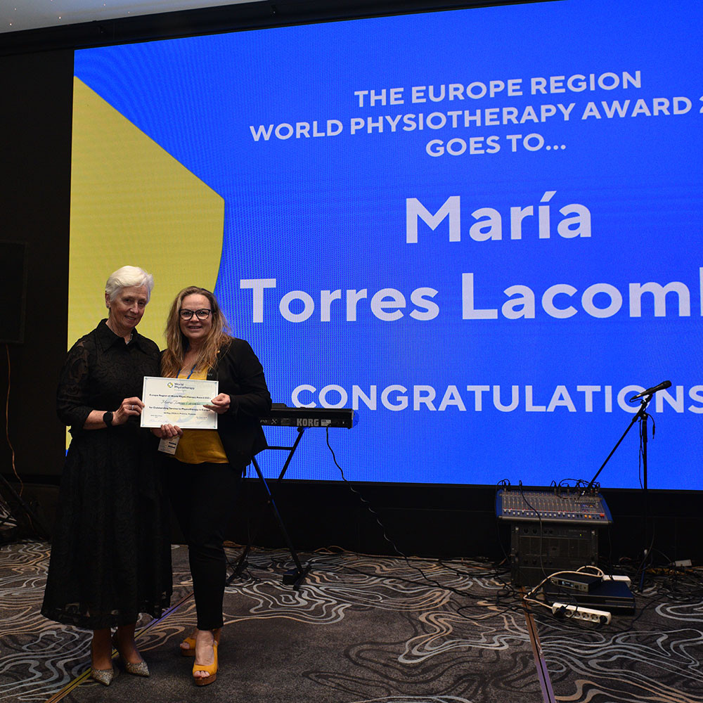 Photo of Maria Torres Lacomba receiving award from Esther-Mary D'Arcy