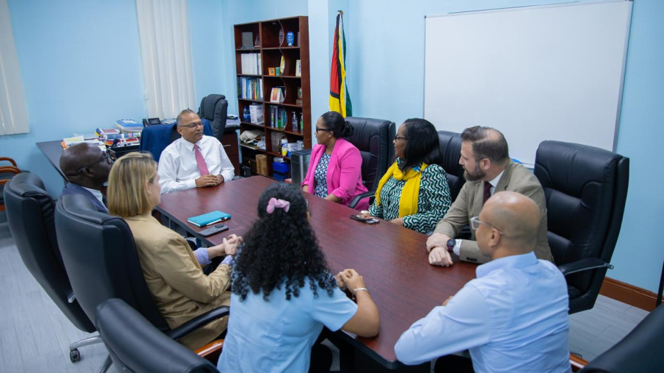 A group of professionals sat around a desk, deep in discussion